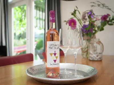 a bottle of wine sitting on a plate with two glasses at Bungalow in South Holland near the Beach in Noordwijk