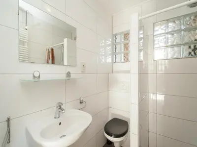 a white bathroom with a sink and a toilet at Bungalow in South Holland near the Beach in Noordwijk