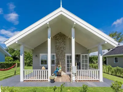 a house with a porch with a swing at Bungalow near Dutch Coast & Forest in Noordwijk