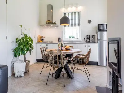 a kitchen with a table and chairs in a room at Bungalow near Dutch Coast & Forest in Noordwijk