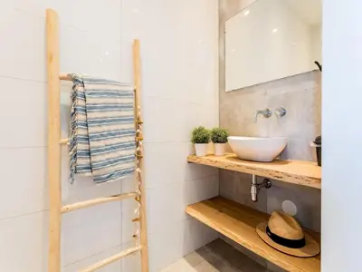 a bathroom with a sink and a mirror at Bungalow near Dutch Coast & Forest in Noordwijk