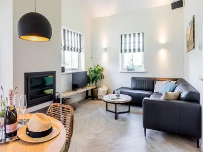 a living room with a couch and a table at Bungalow near Dutch Coast & Forest in Noordwijk