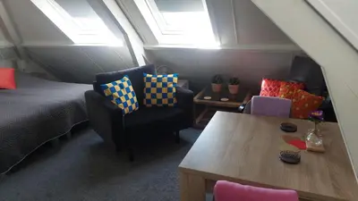 a bedroom with a bed and a table and chairs at Walhalla in Zandvoort