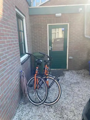 two bikes are parked next to a brick wall at Walhalla in Zandvoort