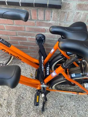 an orange bike parked next to a brick wall at Walhalla in Zandvoort