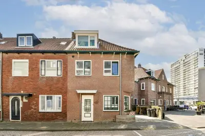 a red brick house with white windows on a street at Walhalla in Zandvoort