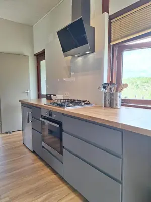 a kitchen with a counter with a stove top oven at Rekerlanden 86 in Warmenhuizen