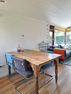 a dining room with a wooden table and chairs at Rekerlanden 86 in Warmenhuizen