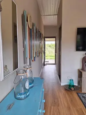 a hallway with a blue table with two fish bowls at Rekerlanden 86 in Warmenhuizen