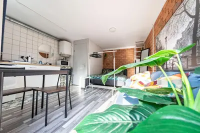 a kitchen and living room with a table and plants at Tiny House Zaandam, Tranquility and easy Connection in Zaandam