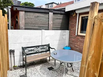 a bench and a table on a patio at Tiny House Zaandam, Tranquility and easy Connection in Zaandam
