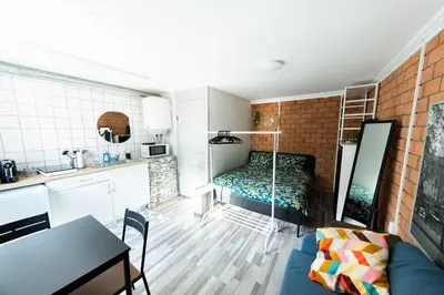 a kitchen and a living room with a bed in a room at Tiny House Zaandam, Tranquility and easy Connection in Zaandam