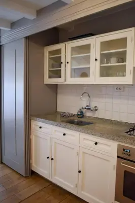 a kitchen with white cabinets and a sink at NEW cosy apartment in 9 streets in Amsterdam