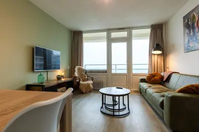 a living room with a couch and a table at Strand166 in Egmond aan Zee