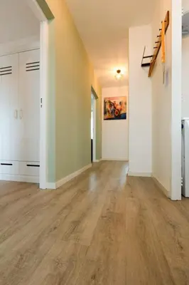 an empty room with wooden floors and white walls at Strand166 in Egmond aan Zee