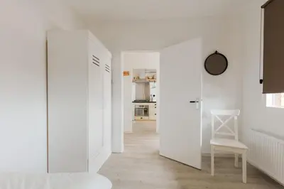 a hallway with white walls and a white chair at Strand166 in Egmond aan Zee