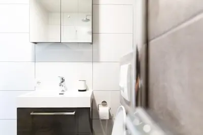 a white bathroom with a sink and a toilet at Strand166 in Egmond aan Zee