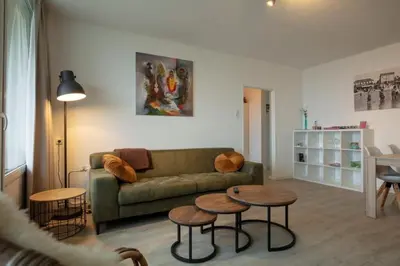a living room with a couch and two tables at Strand166 in Egmond aan Zee