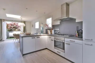 a kitchen with white cabinets and a stove top oven at City apartment Alkmaar in Alkmaar