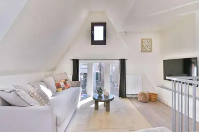 a living room with a white couch and a tv at City apartment Alkmaar in Alkmaar