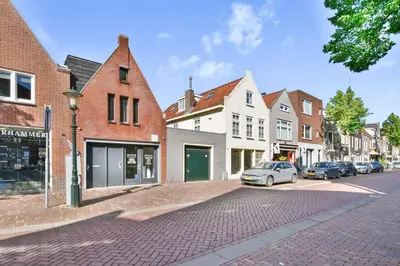 a cobblestone street in a town with buildings at City apartment Alkmaar in Alkmaar