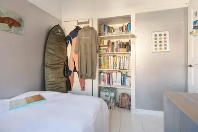 a bedroom with a bed and a book shelf with books at Beachhouse36 in Zandvoort