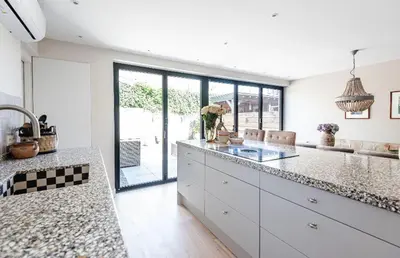a kitchen with white counters and a large window at Beachhouse36 in Zandvoort