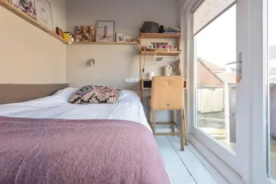 a bedroom with a bed and a desk and a window at Beachhouse36 in Zandvoort