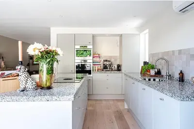a white kitchen with a vase of flowers on a counter at Beachhouse36 in Zandvoort