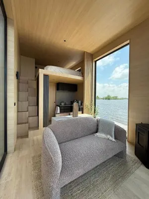 a living room with a couch and a large window at Modern Stay Tiny Houseboat to visit Amsterdam in Monnickendam
