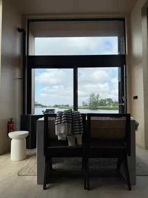 a room with a chair and a large window at Modern Stay Tiny Houseboat to visit Amsterdam in Monnickendam