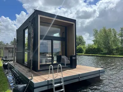 a tiny house on a dock on the water at Modern Stay Tiny Houseboat to visit Amsterdam in Monnickendam