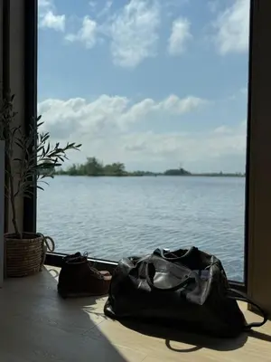 a black bag sitting on a table in front of a window at Modern Stay Tiny Houseboat to visit Amsterdam in Monnickendam