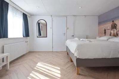 a bedroom with a bed and a painting on the wall at Therese with free parking in Zandvoort