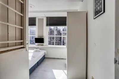a bedroom with a bed and a television in a window at Authentic apartment in Alkmaar in Alkmaar