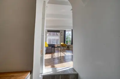 a hallway leading to a living room with yellow chairs at Authentic apartment in Alkmaar in Alkmaar