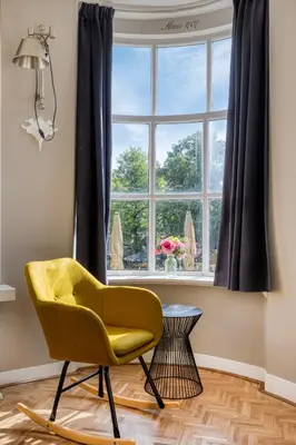 a yellow chair in a room with a window at Authentic apartment in Alkmaar in Alkmaar
