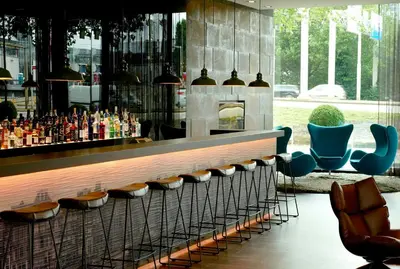 a bar in a building with chairs and bottles at Motel One Amsterdam in Amsterdam