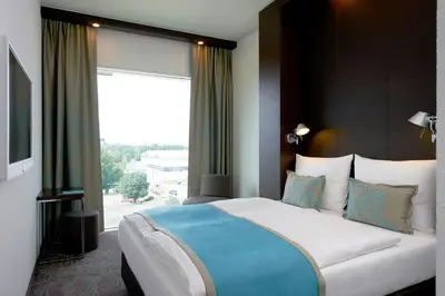 a bedroom with a large bed with a large window at Motel One Amsterdam in Amsterdam
