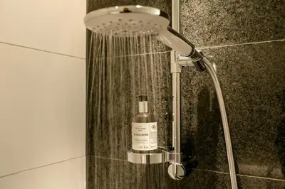 a shower in a bathroom with a bottle of soap at Motel One Amsterdam in Amsterdam