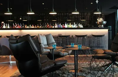 a bar with two tables and chairs in a room at Motel One Amsterdam in Amsterdam