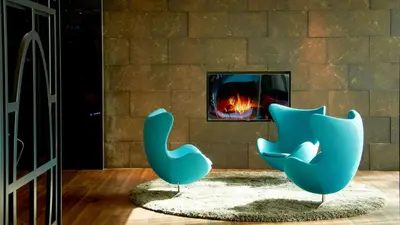 two blue chairs sitting in front of a fireplace at Motel One Amsterdam in Amsterdam