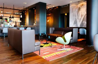 a lobby with chairs and a table and a bar at Motel One Amsterdam in Amsterdam