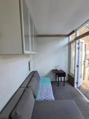 a living room with a couch and a table at Tiny Garden Room - in city center in Alkmaar