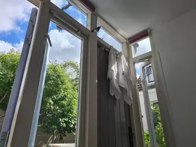 a window with white clothes hanging in it at Tiny Garden Room - in city center in Alkmaar