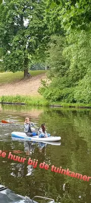 two people are riding on a raft in the water at Tiny Garden Room - in city center in Alkmaar