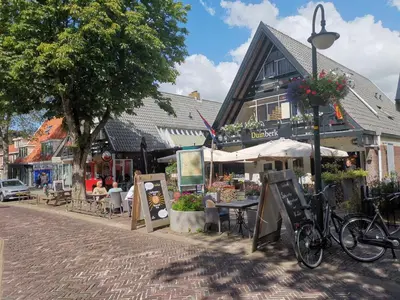 a street with tables and chairs and a building at Duinberk B&B hotel en Brasserie in Schoorl