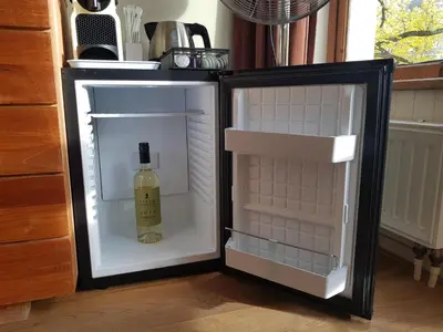 a bottle of wine sitting inside of an empty refrigerator at A B&B Amsterdam in Amsterdam
