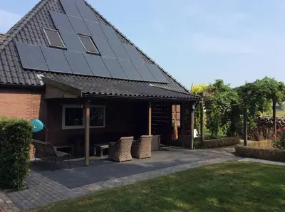a house with solar panels on the roof at Bed & Breakfast De Stolp in Zuidoostbeemster