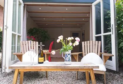 a table with two chairs and a bottle of wine at B&B Goldie in Aerdenhout
